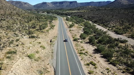 Aerial-Tracking-Shot-Of-Tourists-Travelling-On-A-Desert-Highway,-travel-Destination-In-America