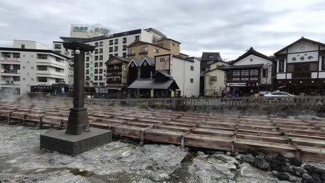 Beautiful-Yubatake-hot-spring-fields-in-Kusatu-Onsen,-Japan-on-cloudy-day-with-typical-shops
