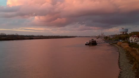 Pan-over-pink-reflecting-light-off-clouds-and-ships-docking-station
