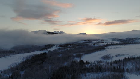 Malerische-Schneebedeckte-Arktische-Wildnis-Mit-Tief-Fließendem-Nebel---Sonnenuntergangsantenne