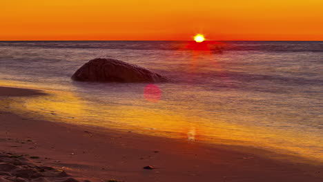 Golden-sunrise-on-a-sandy-beach---long-exposure-time-lapse