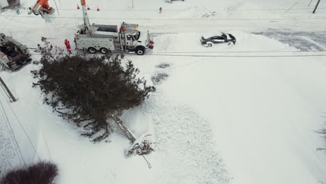 Aerial-footage-of-emergency-services-clearing-a-fallen-tree-after-a-snowstorm,-highlighting-their-vital-role-in-responding-to-natural-disasters