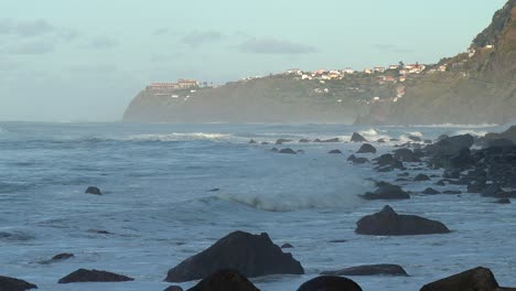 Landscape-shot-of-the-city-in-the-North-Coast-of-Madeira-Island,-Portugal-with-rocks-crashing-on-the-beach
