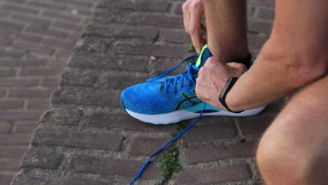 Primer-Plano-Y-Enfoque-En-Las-Manos-De-Trail-Runner-Desatar-Y-Atar-Los-Cordones-De-Los-Zapatos-De-Forma-Segura-Antes-De-Una-Carrera-Limpiando-El-Equipo-Especializado