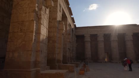 Tourists-look-around-in-second-court-of-Medinet-Habu-temple,-tourist-attraction-of-ancient-Egypt