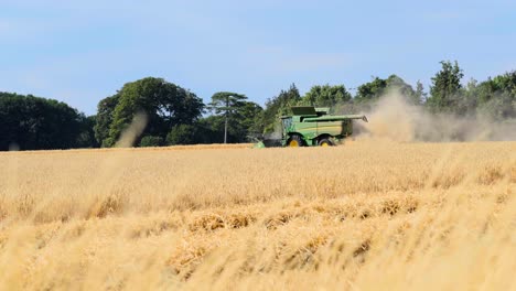 Close-up-shot-of-a-combine-harvester-on-a-summers-day-with-foreground-4K