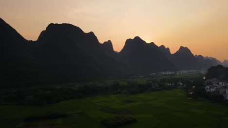 Mountain-Silhouettes-at-Sunset-in-Guilin-Yangshuo,-China---Aerial-Drone-Flight