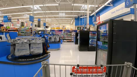POV---Pushing-a-grocery-cart-past-registers-and-customers-standing-in-a-queue-to-checkout-at-a-large-American-mega-mart