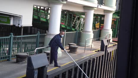 Asian-dock-worker-securing-boat-central-dock-Hong-kong,-China