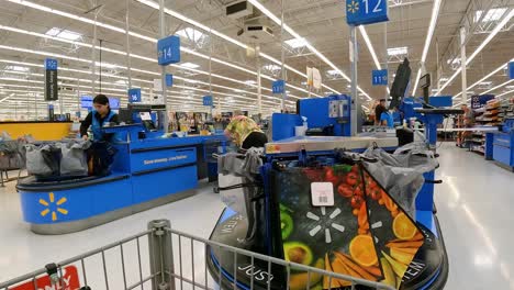 POV---Pushing-a-grocery-cart-past-registers-and-customers-standing-in-a-queue-to-checkout-at-a-large-American-mega-mart