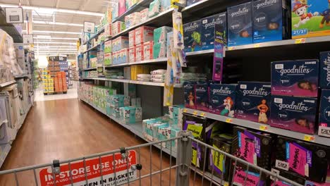 POV---Pushing-a-grocery-cart-past-the-displays-of-disposable-diapers-and-infant-wipes-in-an-American-grocery-store