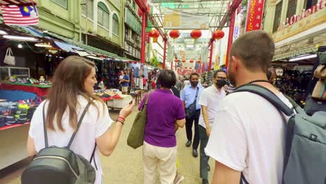 Folgende-Aufnahme-Ausländischer-Touristen,-Die-Tagsüber-Einen-Spaziergang-Durch-überfüllte-Straßenstände-Auf-Dem-Straßenmarkt-In-Kuala-Lumpur,-Malaysia,-Genießen