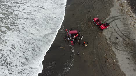 Indonesia---Feb-5,-2023-:-a-red-car-stuck-in-the-sand-by-the-beach