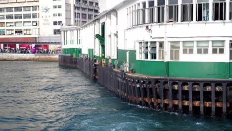 POV-from-back-of-Star-Ferry-leaving-dock-in-Tsim-Sha-Tsui,-Hong-Kong