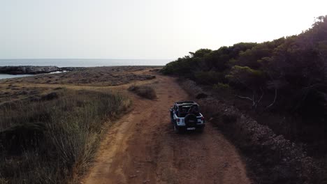 Family-on-vacation-in-jeep-heads-towards-the-sea,-in-Favignana-Island,-sicily