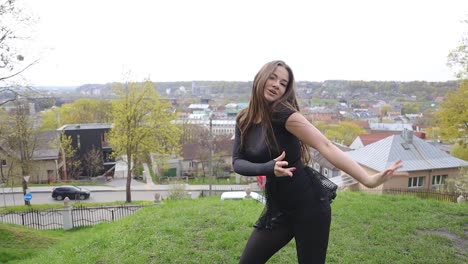 Energetic-Caucasian-female-dancer-dancing-up-on-a-hill-in-a-city-park