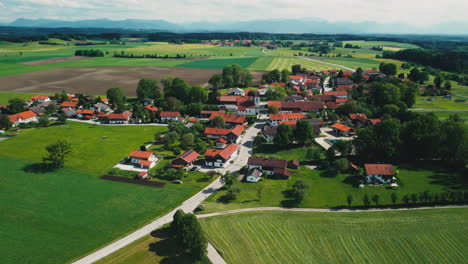 Western-Germany's-countryside-with-aerial-footage-showcasing-peaceful-villages,-mowing-tractors,-and-harvested-fields-under-clear-blue-skies