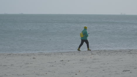 Lone-Person-Walking-Through-Peaceful-Sandy-Foreshore-In-A-Misty-Morning