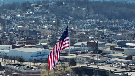 Largo-Zoom-Aéreo-De-La-Bandera-Americana-Ondeando-Frente-Al-Paisaje-Invernal-En-Un-Pequeño-Pueblo-De-América