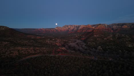 Aerial-view-revealing-twilight-of-Sedona-City-and-red-rocks-as-moon-rises-over-Oak-Creek