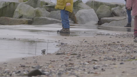Kinder-Am-Meeresufer-Waten-In-Der-Nähe-Der-Plätschernden-Wellen-Des-Strandes