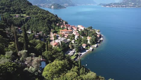 Aerial-backwards-shot-showing-small-village-named-Verdana-bordering-Lake-Como-in-Italy-during-summer