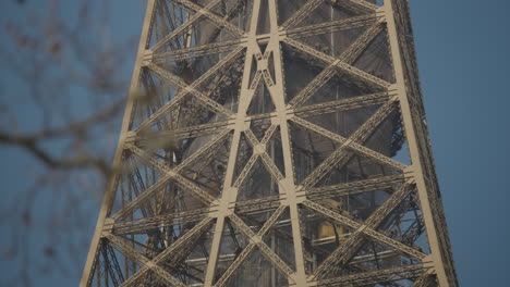 Elevator-goes-up-to-the-top-of-the-famous-Eiffel-tower,-slow-motion-tilt-up