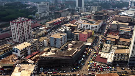 Aerial-view-of-a-city-market-and-the-Hotel-Adamaoua,-in-Yaounde,-Cameroon---tracking,-drone-shot