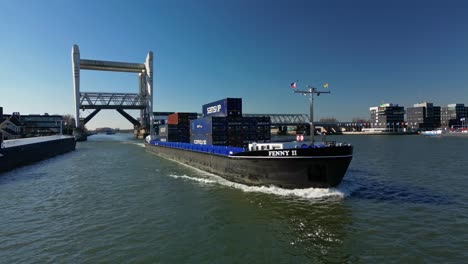 Containership-navigating-through-canal-in-Dordt,-The-Netherlands-that-just-came-out-of-the-drawbridge