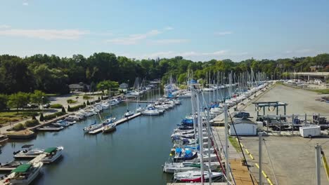 Drone-flying-close-to-docked-sailboats-in-a-sunny-Oakville-harbor