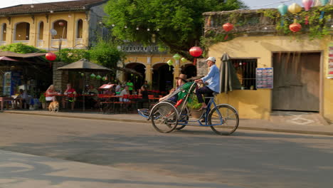 Eine-Tracking-Aufnahme-Eines-Touristen,-Der-Mit-Einem-Fahrradverleih-Durch-Die-Stadt-Hoi-An-In-Vietnam-Fährt