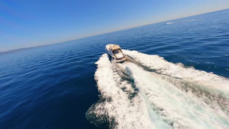 FPV-Antenne-Umkreist-Eine-Yacht,-Die-Vor-Der-Küste-Spaniens-Segelt,-Während-Ein-Mann-An-Deck-Ein-Sonnenbad-Nimmt