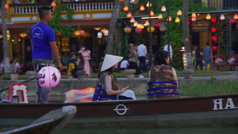 Turistas-Que-Toman-Un-Paseo-En-Bote-De-Farolillos-En-El-Río-Hoai-En-Un-Bote-Sampán-En-La-Antigua-Ciudad-De-Hoi-An-Al-Atardecer,-Vietnam