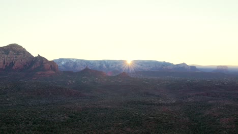 First-light-cresting-over-mountains-creating-sun-star-flare-in-morning-in-Sedona