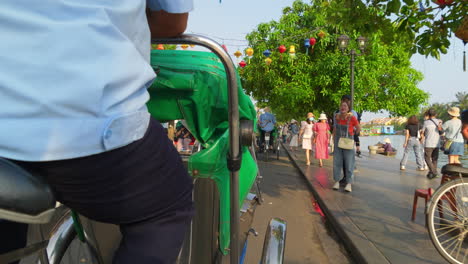 Eine-Perspektivische-Aufnahme-Eines-Touristischen-Passagiers,-Der-Auf-Einem-örtlichen-Fahrradtransportmittel-Auf-Der-Rechten-Seite-Fährt,-Um-Durch-Die-Stadt-Hoi-An-In-Vietnam-Zu-Streifen