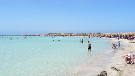Los-Turistas-Nadan-En-Un-Agua-Clara-De-La-Playa-De-Elafonissi-En-Verano-En-La-Isla-De-Creta,-Grecia