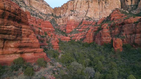 Low-angle-aerial-view-of-red-rock-mountains-flying-in-Sedona-Arizona