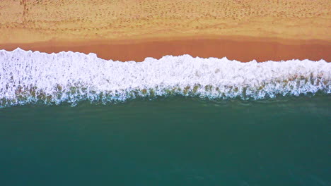 Large-ocean-wave-washing-sandy-beach-with-white-foam,-Thailand