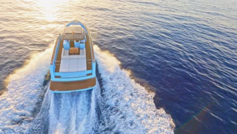 FPV-aerial-flying-around-a-luxury-yacht-speeding-into-the-sunset-off-the-coast-of-Ibiza