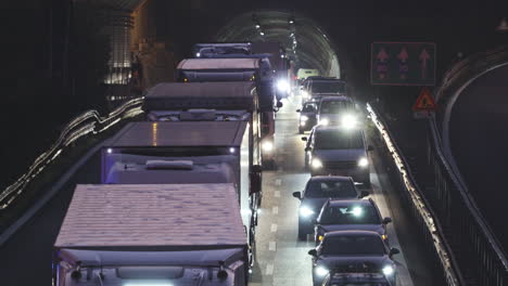 Lange-Teleaufnahme-Von-Stark-Befahrenen-Fahrzeugen,-Die-Langsam-Aus-Dem-Tunnel-Herausfahren