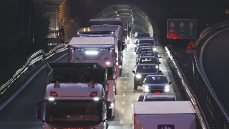 Autopista-De-Tráfico-Pesado-Por-La-Noche,-Automóviles-Y-Camiones-Que-Salen-Del-Túnel,-Estático