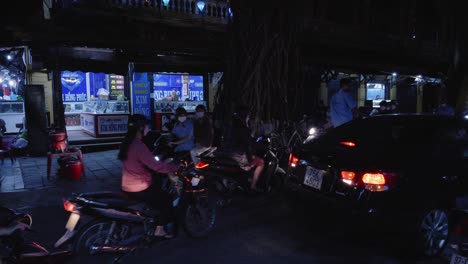 Busy-street-traffic-in-Hoi-An,-Vietnam,-with-motorbikes-driving-along-the-road