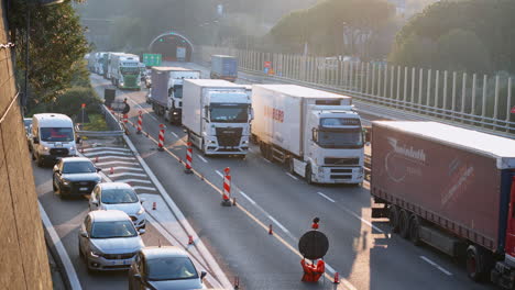 Static-establisher-shot-of-heavy-traffic-road-section,-many-trucks-and-cars