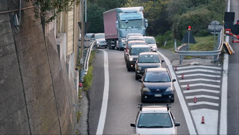 Tráfico-Pesado-En-Una-Carretera-Italiana,-Muchos-Coches-Y-Camiones-Conduciendo-Lentamente,-Obras-Viales