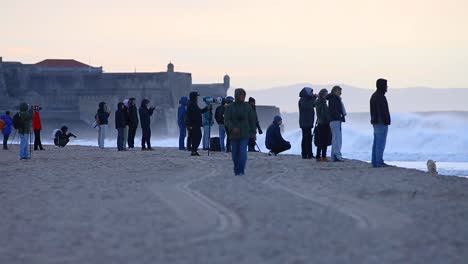 Capturado-En-Una-Toma-Amplia,-El-Campeonato-De-Surf-De-Billabong-En-La-Playa-De-Carcavelos,-Portugal,-Es-Una-Demostración-Emocionante-De-Habilidad-Y-Pasión,-Con-Una-Playa-Llena-De-Gente-Y-Un-Fuerte-Que-Sirve-Como-Telón-De-Fondo-Perfecto