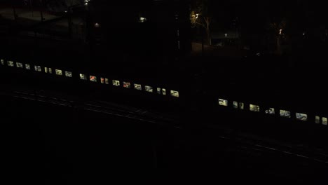 Tren-De-Metro-En-Movimiento-En-La-Vía-Férrea-Urbana-Durante-La-Noche-En-Melbourne,-Australia