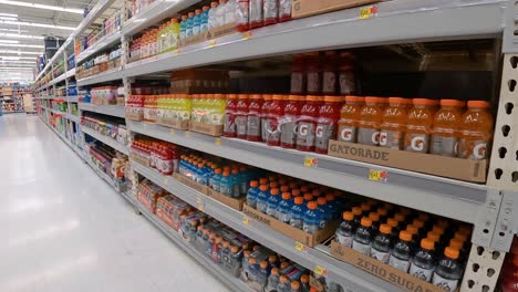 Slowly-passing-displays-of-sports-drink-and-soda-pop-in-an-American-mega-grocery-store