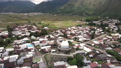 Cultural-Islam-Sembalun-village-with-mosque-construction-and-agriculture-land-with-Volcano-mountain-range-at-the-background-near-volcano-Rijani-National-Park,-Lombok,-Indonesia
