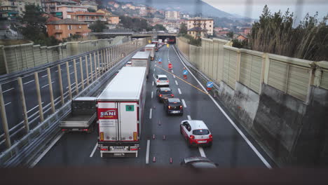 Tiro-De-Inclinación-Del-Establecidor-De-La-Carretera-Italiana-Con-Mucho-Tráfico-Al-Atardecer,-Camiones-Y-Automóviles