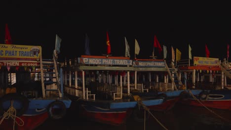 Toma-Nocturna-De-Barcos-Amarrados-En-El-Paseo-Marítimo-Del-Río-Thu-Bon-En-Hoi-An,-Vietnam